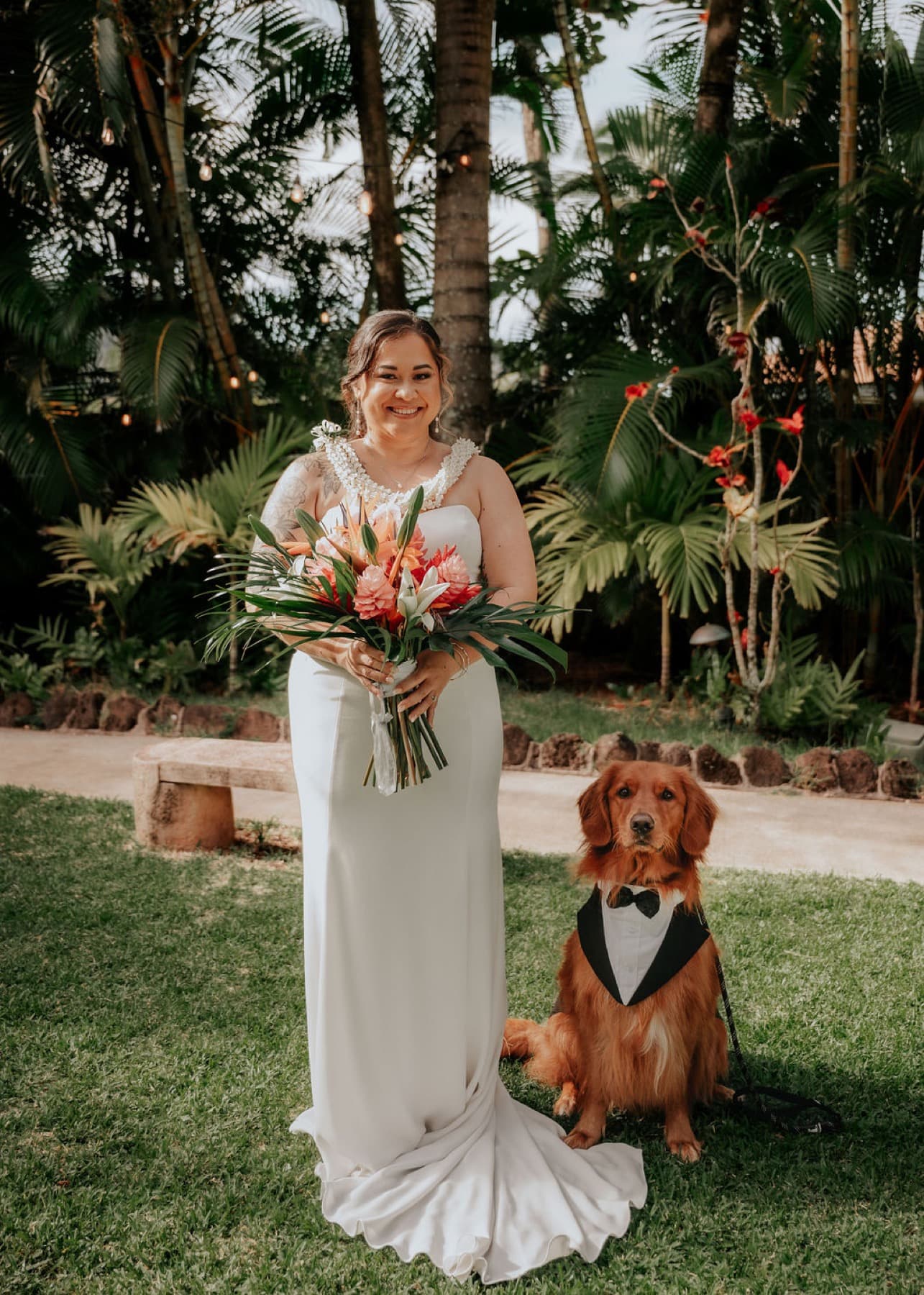 Bride walking to the ceremony with the couple's golden retriever in a tuxedo