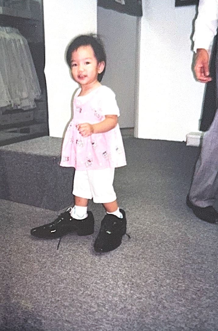 Toddler Lauren swimming in a pair of oversized adult dress shoes
