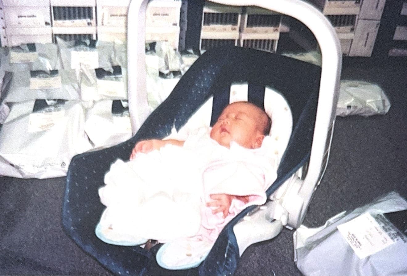 Newborn Lauren asleep in a car seat on the floor of Black Tie Affair